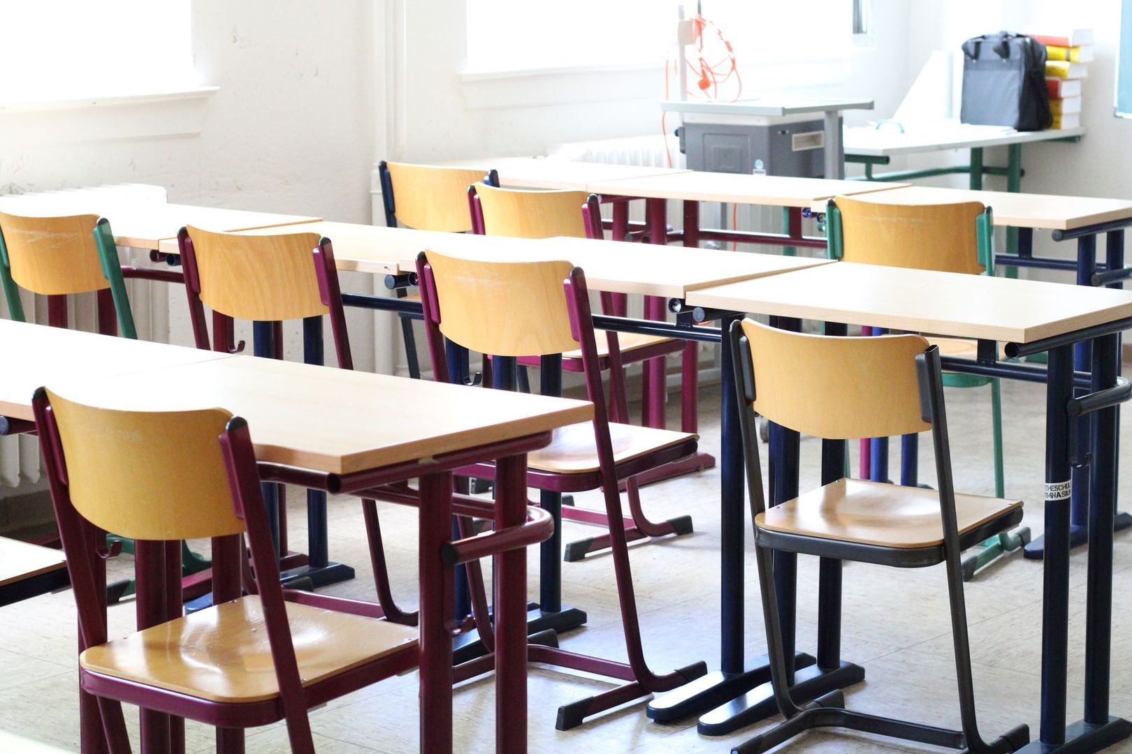 An empty classroom with wooden desks and chairs, representing the Swiss education system.