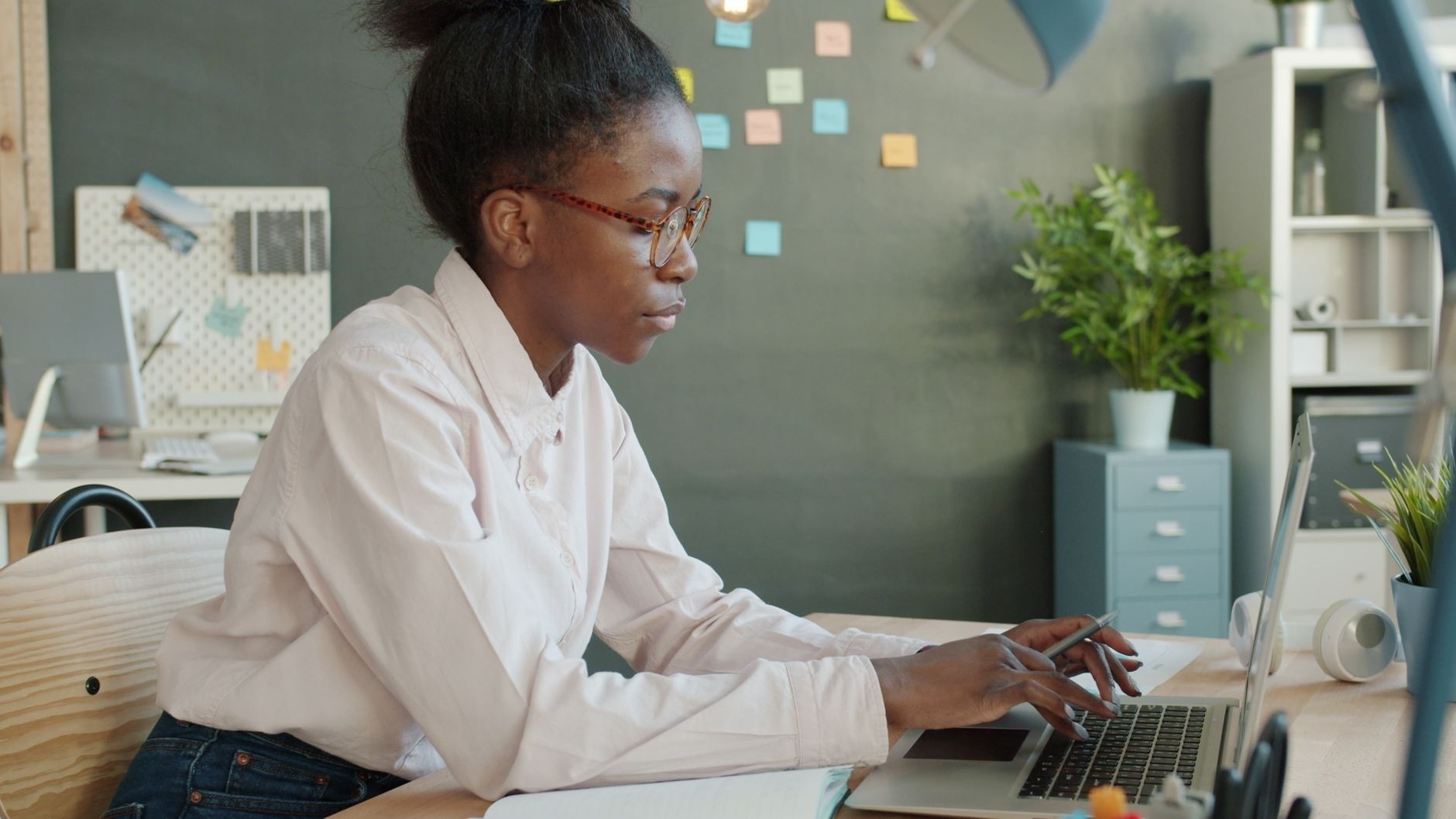 Adult student working on a laptop at a desk in a home office